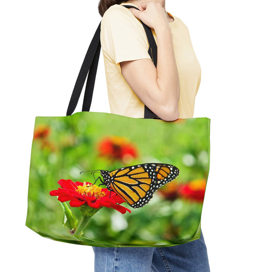 Young woman with a weekender bag featuring the butterfly on flower design hanging from her shoulder.