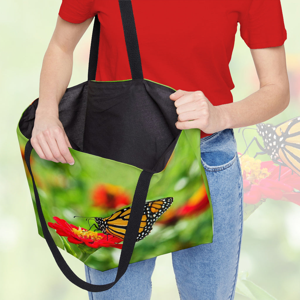 A woman holding open a weekender bag featuring the butterfly on flower design, showcasing the roomy interior.