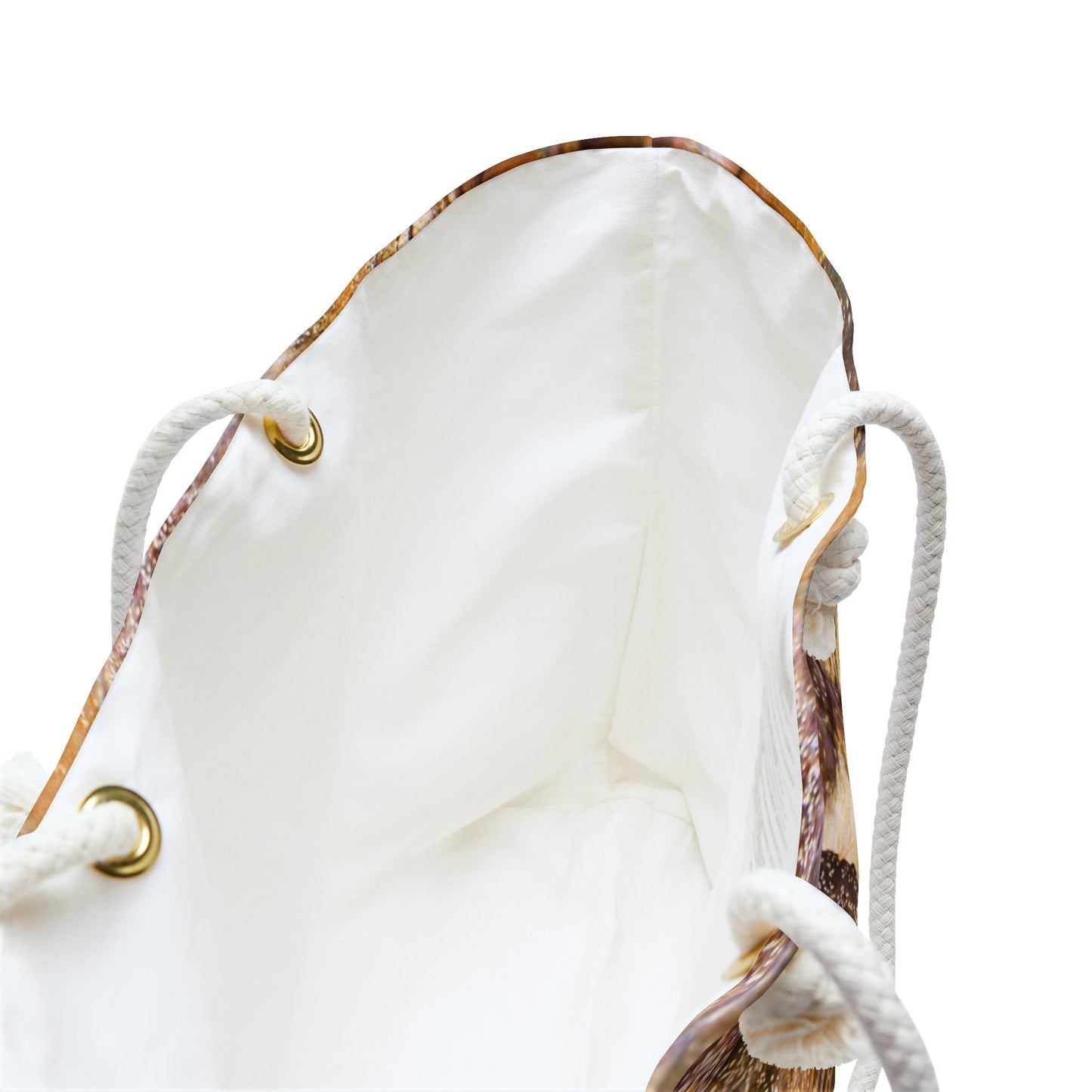 A close up view of the beach bag with orange bark design shows the braided rope handles with metal grommets.