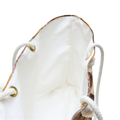 A close up view of the beach bag with orange bark design shows the braided rope handles with metal grommets.