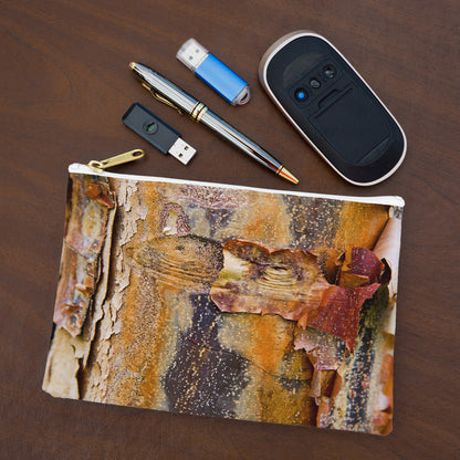 Small pouch with orange bark design lying flat on desktop with thumb drives, computer mouse and pen.