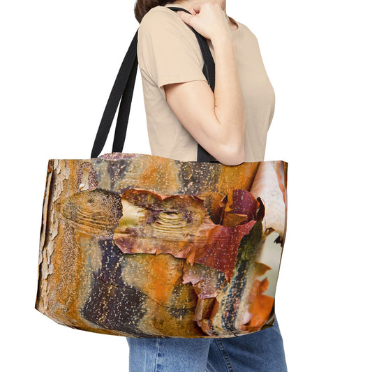 Young woman with a weekender bag featuring the orange bark design hanging from her shoulder.