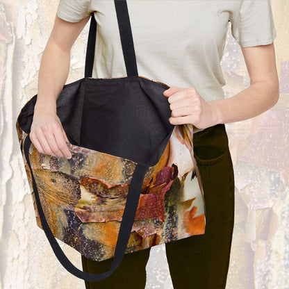 A woman holding open a weekender bag featuring the orange bark design, showcasing the roomy interior.