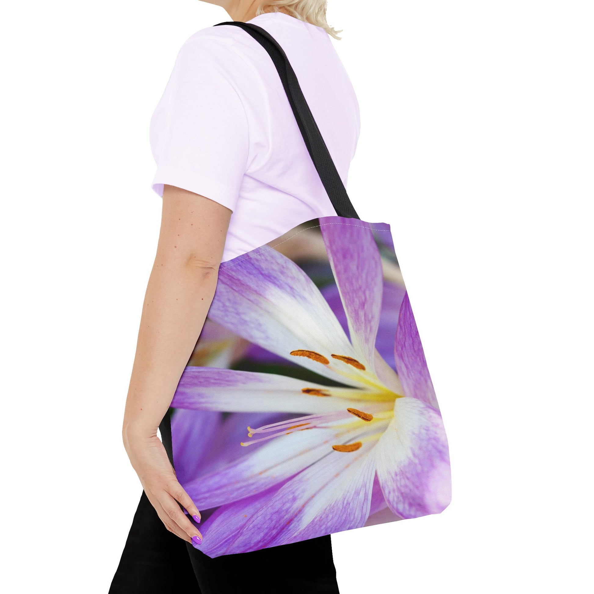 Young woman with a tote bag featuring the purple flower, orange stamen design draped across her shoulder.