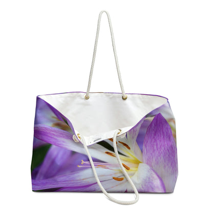 An open view of the beach bag with purple flowers, orange stamen design shows the cream colored interior lining.
