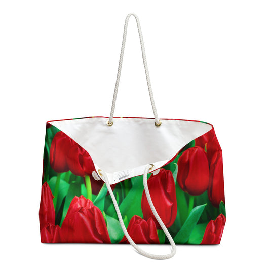 An open view of the beach bag with red tulips design shows the cream colored interior lining.