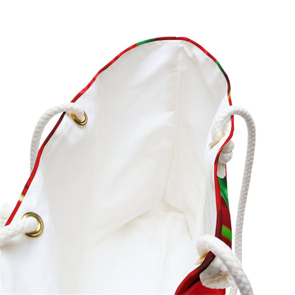 A close up view of the beach bag with red tulips design shows the braided rope handles with metal grommets.
