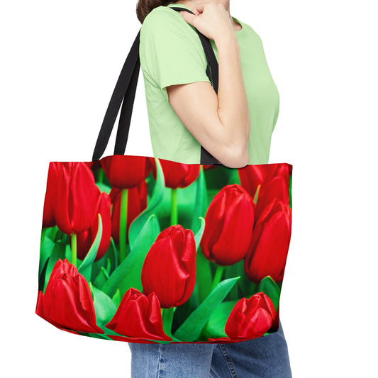 Young woman with a weekender bag featuring the red tulips design hanging from her shoulder.