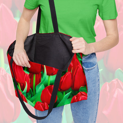 A woman holding open a weekender bag featuring the red tulips design, showcasing the roomy interior.