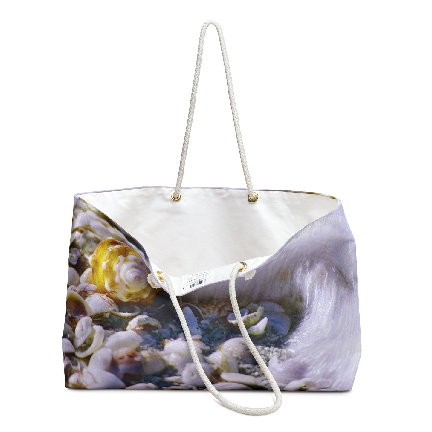An open view of the beach bag with shell in surf design shows the cream colored interior lining.
