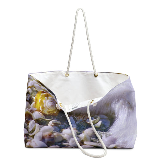An open view of the beach bag with shell in surf design shows the cream colored interior lining.