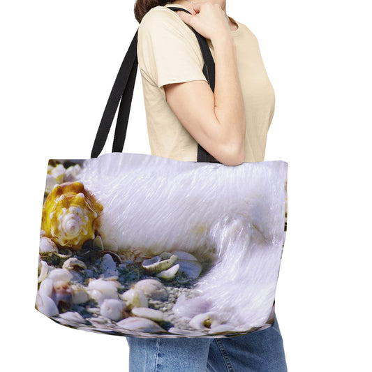 Young woman with a weekender bag featuring the shell in surf design hanging from her shoulder.