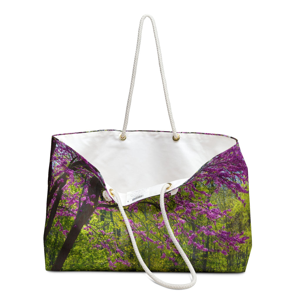 An open view of the beach bag with tree blossoms design shows the cream colored interior lining.