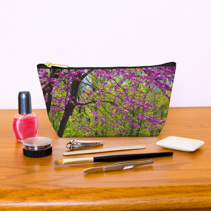 Kit bag with tree blossoms design next to nail polish, tweezers, nail clippers, makeup brush, blush and eye shadow.