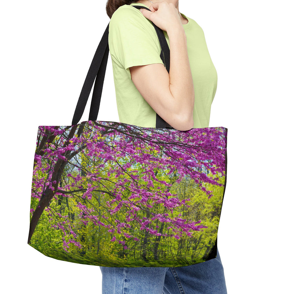 Young woman with a weekender bag featuring the tree blossoms design hanging from her shoulder.