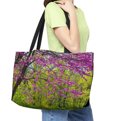 Young woman with a weekender bag featuring the tree blossoms design hanging from her shoulder.