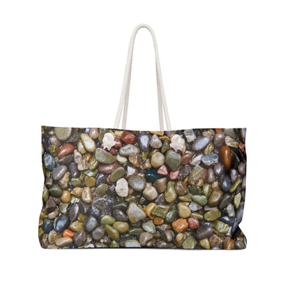 Front view of a beach bag featuring vibrant photo art close up of wet glistening multi colored pebbles and stones.