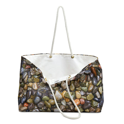 An open view of the beach bag with pebbles and stones design shows the cream colored interior lining.