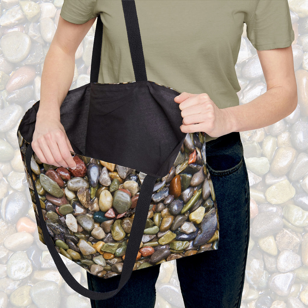 A woman holding open a weekender bag featuring the pebbles and stones design, showcasing the roomy interior.