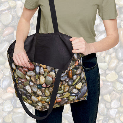 A woman holding open a weekender bag featuring the pebbles and stones design, showcasing the roomy interior.