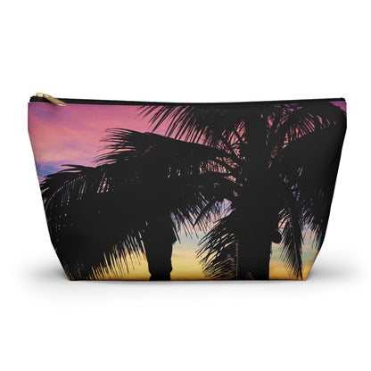 Zippered accessory pouch featuring vibrant photo art of intense multi colored sunset with black palm trees in the foreground.