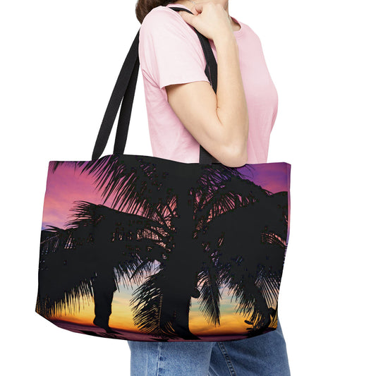 Young woman with a weekender bag featuring the intense sunset design hanging from her shoulder.