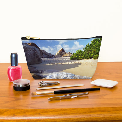 Kit bag with beach surf design next to nail polish, tweezers, nail clippers, makeup brush, blush and eye shadow.
