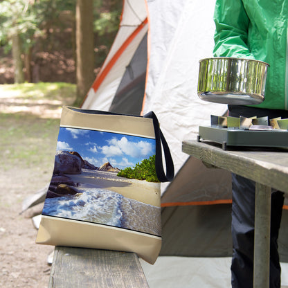 A tote bag featuring the beach surf design sits on the bench of a campsite picnic table as the camper cooks.