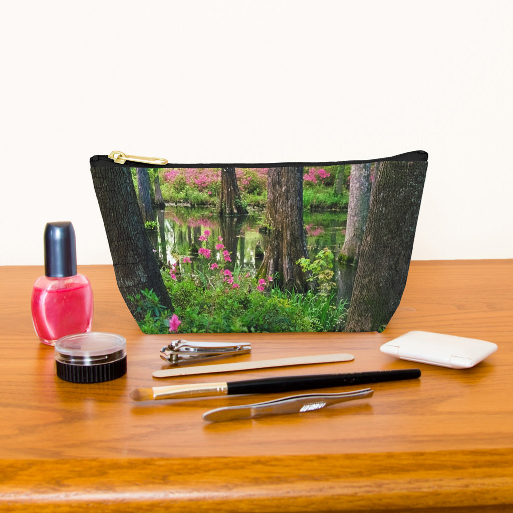 Kit bag with wetland design next to nail polish, tweezers, nail clippers, makeup brush, blush and eye shadow.