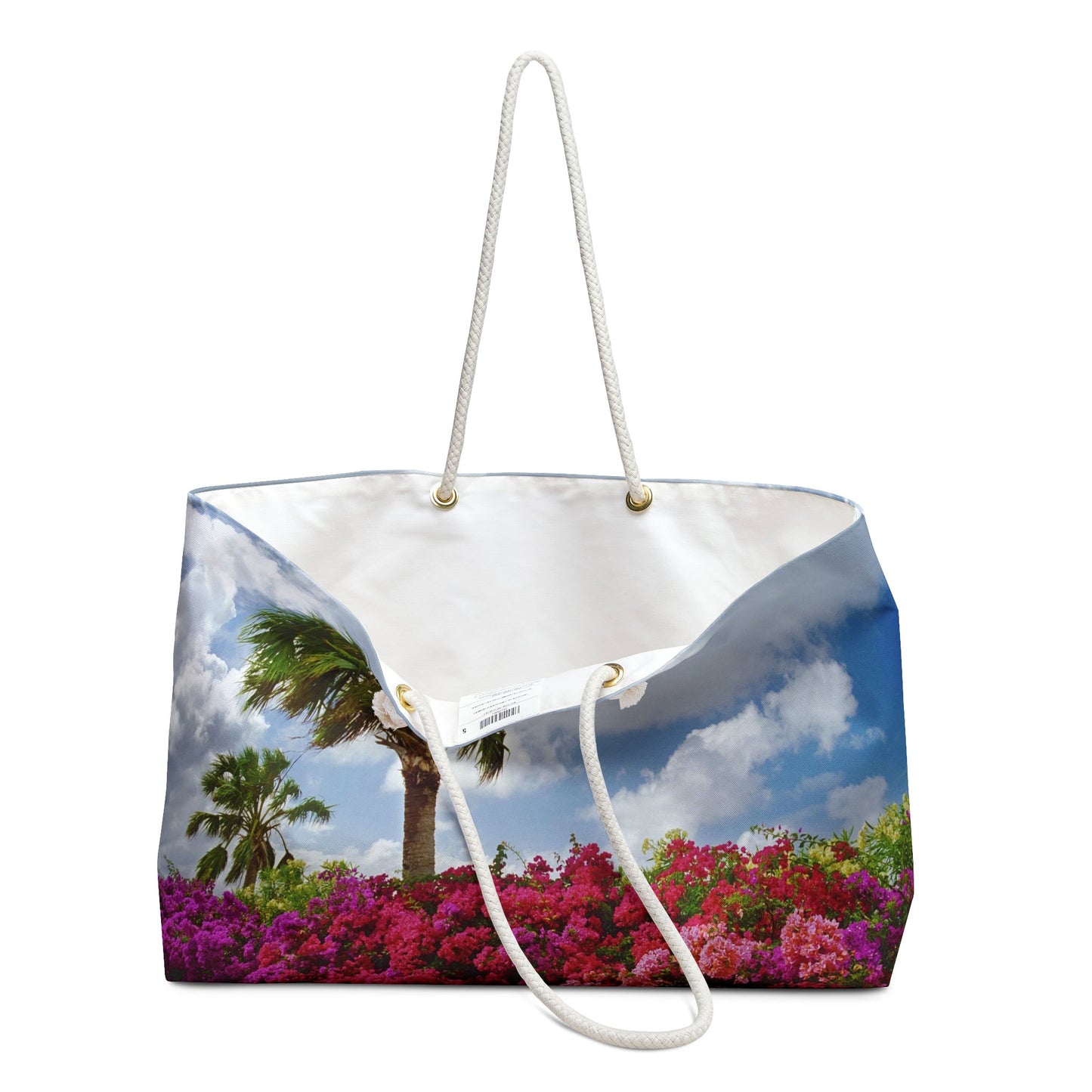 An open view of the beach bag with tropical flowers design shows the cream colored interior lining.