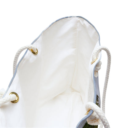 A close up view of the beach bag with tropical flowers design shows the braided rope handles with metal grommets.