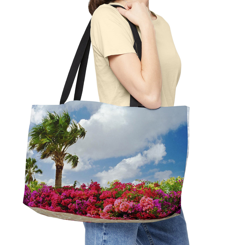 Young woman with a weekender bag featuring the tropical flowers design hanging from her shoulder.