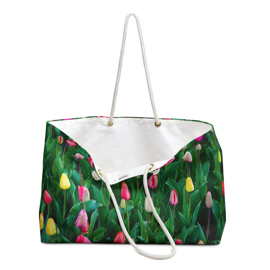 An open view of the beach bag with multi colored tulips design shows the cream colored interior lining.