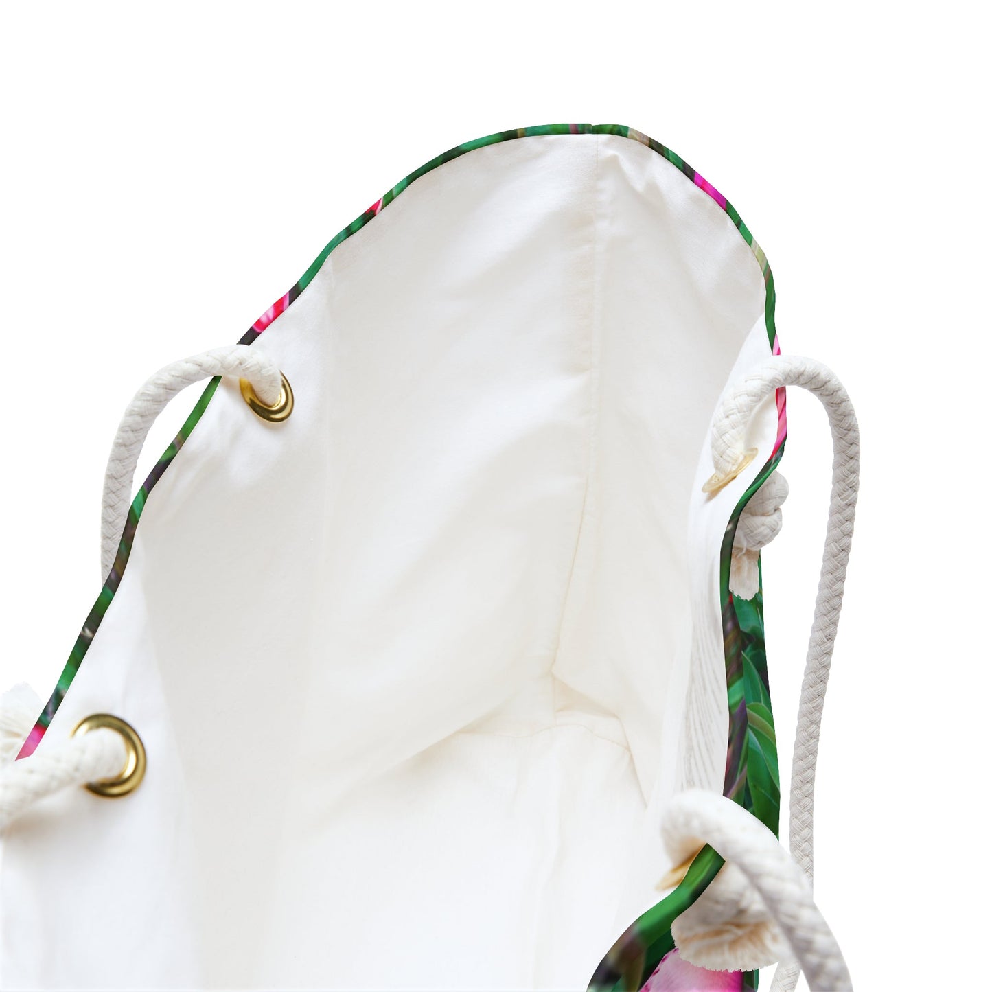 A close up view of the beach bag with multi colored tulips design shows the braided rope handles with metal grommets