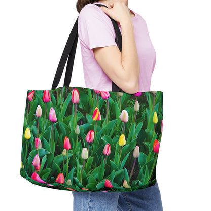 Young woman with a weekender bag featuring the multi colored tulips design hanging from her shoulder.