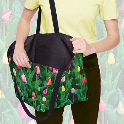 A woman holding open a weekender bag featuring the multi colored tulips design, showcasing the roomy interior.