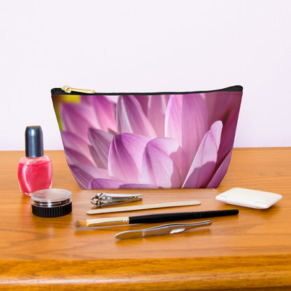 Kit bag with flower petals design next to nail polish, tweezers, nail clippers, makeup brush, blush and eye shadow.
