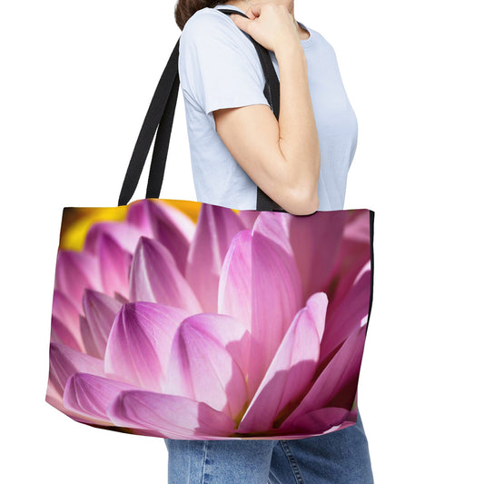 Young woman with a weekender bag featuring the flower petals design hanging from her shoulder.