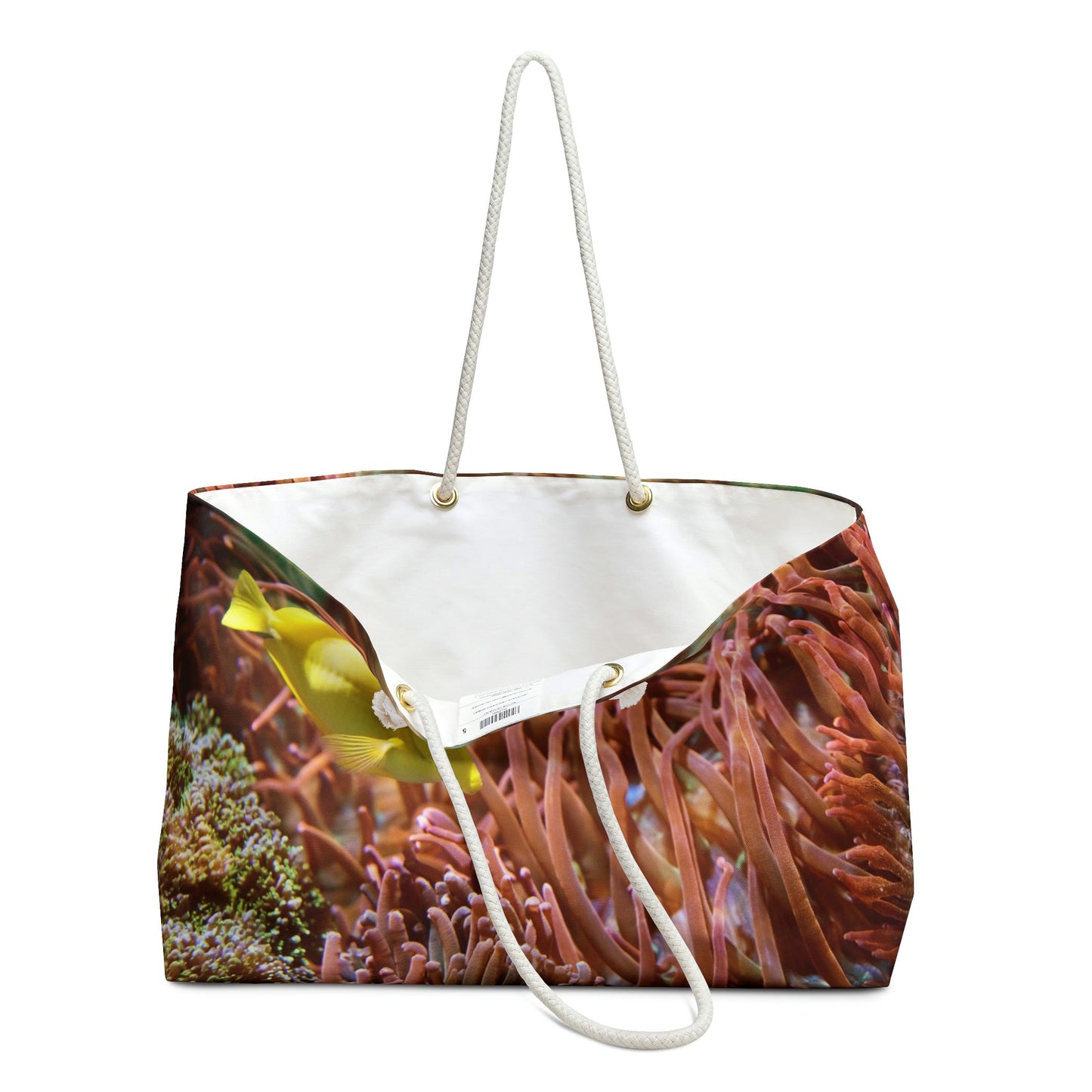 An open view of the beach bag with yellow fish design shows the cream colored interior lining.
