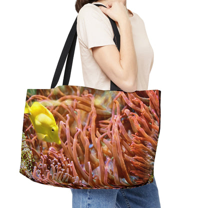 Young woman with a weekender bag featuring the yellow fish design hanging from her shoulder.