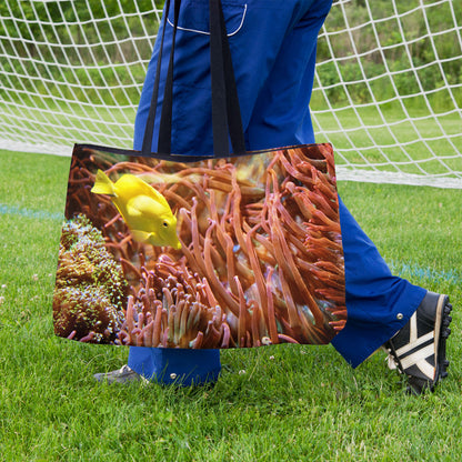 A soccer player carrying a weekender bag featuring the yellow fish design onto the practice field.